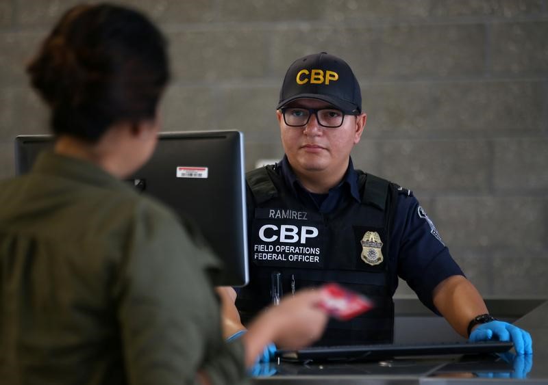 © Reuters. A U.S. Customs and Border Patrol officer interviews people entering the United States from Mexico at the border crossing in San Ysidro