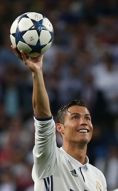 © Reuters. Foto del martes del delantero del Real Madrid Cristiano Ronaldo celebrando su tripleta con el balón del partido tras la victoria sobre Bayern Munich