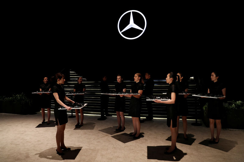 © Reuters. Women hold translation equipment during a Daimler's event ahead of the Shanghai Autoshow in Shanghai