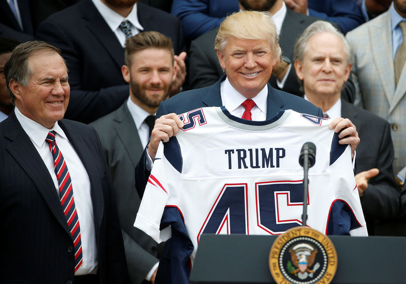 © Reuters. U.S. President Donald Trump holds up a New England Patriots jersey as Head Coach Bill Belichick watches during an event honoring the Super Bowl champion New England Patriots at the White House in Washington