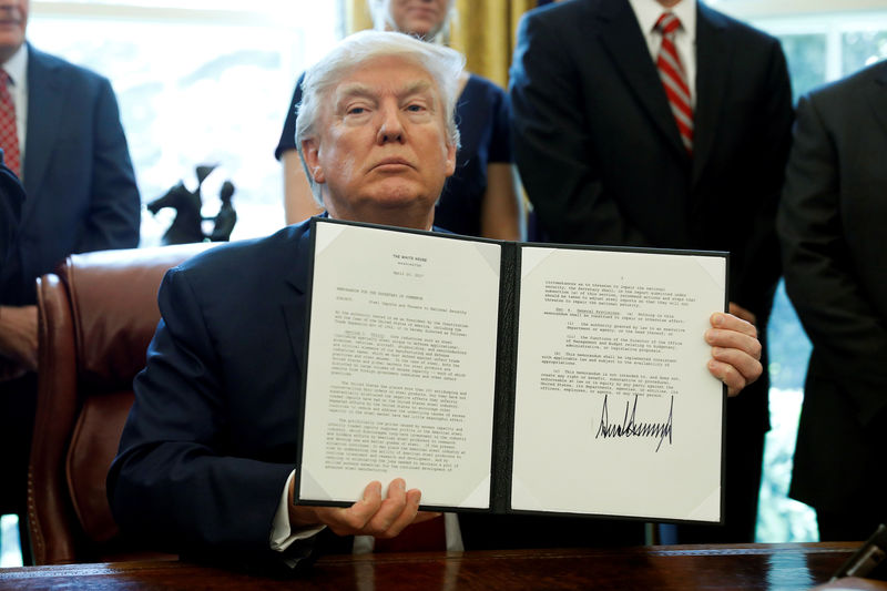 © Reuters. U.S. President Donald Trump holds up a directive ordering an investigation into the impact of foreign steel on the American economy after signing it in the Oval Office of the White House