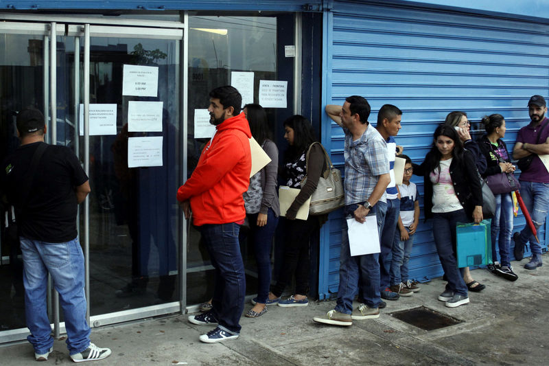 © Reuters. People line up outside a branch of Italcambio currency exchange in San Cristobal