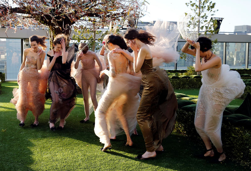 © Reuters. Models struggle against strong wind before the rehearsal of Christian Dior's Haute Couture Spring-Summer 2017 live show to celebrate Dior's new flagship store at the rooftop of Ginza Six mall in Tokyo