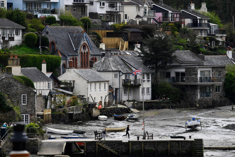 © Reuters. A union jack flutters as locals play by the harbour in Newton Ferrers