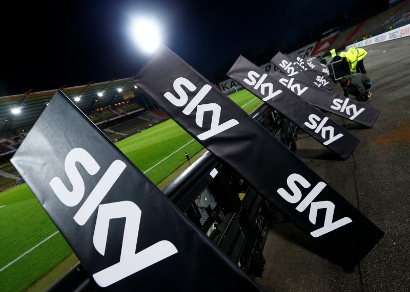 © Reuters. Workers remove the advertising of Sky TV provider after the German Bundesliga second leg relegation playoff soccer match between Karlsruhe SC and Hamburg SV in Karlsruhe