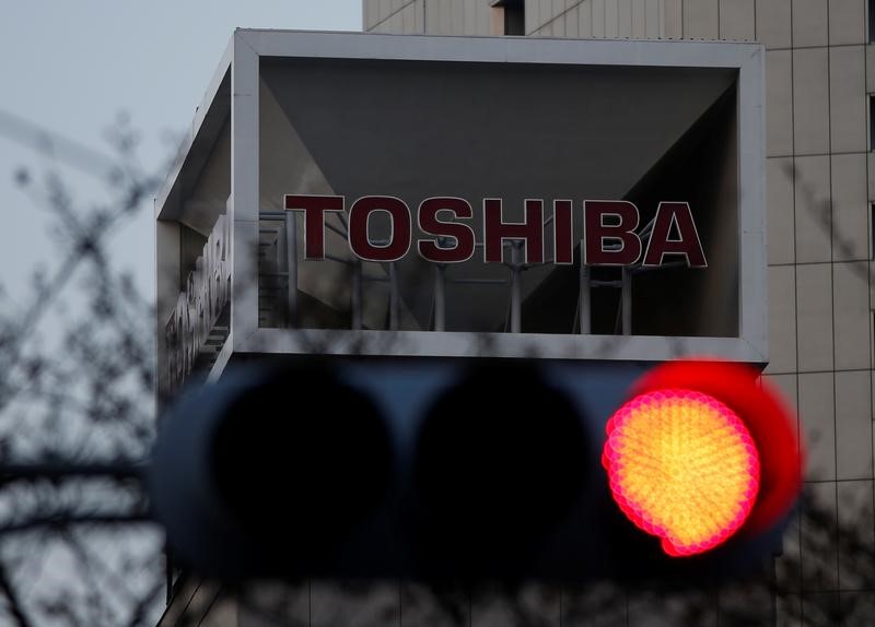 © Reuters. The logo of Toshiba Corp is seen behind a traffic light at the company's headquarters in Tokyo