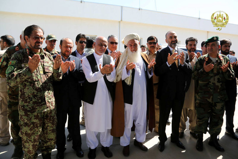 © Reuters. Afghanistan's President Ashraf Ghani (3rd L) prays for the victims of April 21's attack on an army headquarters during his visits in Mazar-i-Sharif