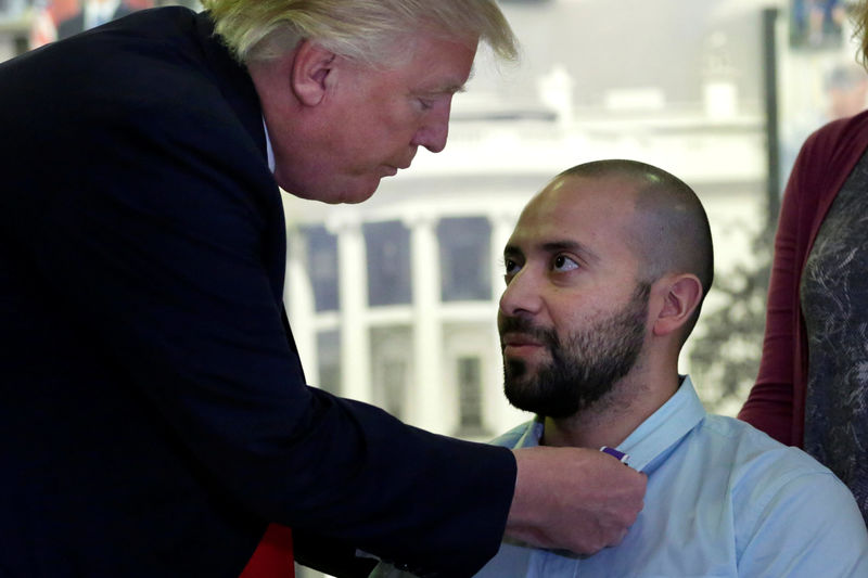 © Reuters. President Donald Trump awards a Purple Heart to Army Sgt First Class Alvaro Barrientos