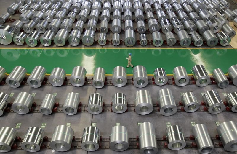 © Reuters. An employee walks past columns of steel as she works at a steel production factory in Wuhan