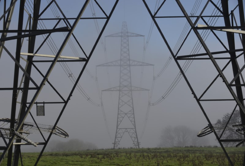 © Reuters. Fog begins to clear from electricity pylons near LLanddowror