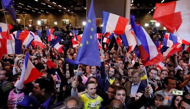 © Reuters. Supporters of Emmanuel Macron, head of the political movement En Marche !, or Onwards !, and candidate for the 2017 French presidential election, react after early results in the first round of 2017 French presidential election in Paris