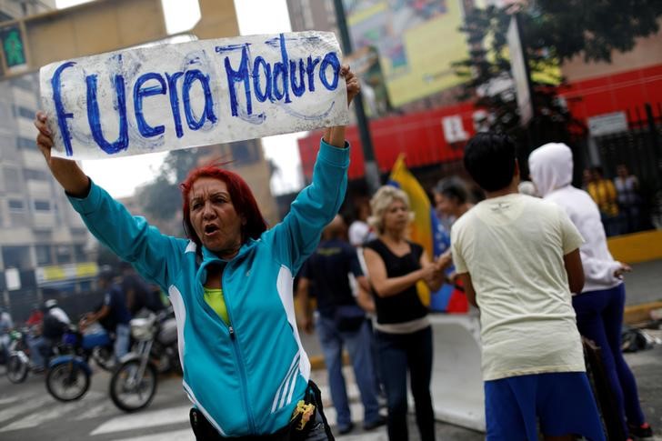 © Reuters. Manifestante da oposição segura cartaz que diz "Fora Maduro", durante protesto em Caracas