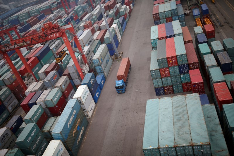 © Reuters. A truck drives between shipping containers at a container terminal at Incheon port in Incheon