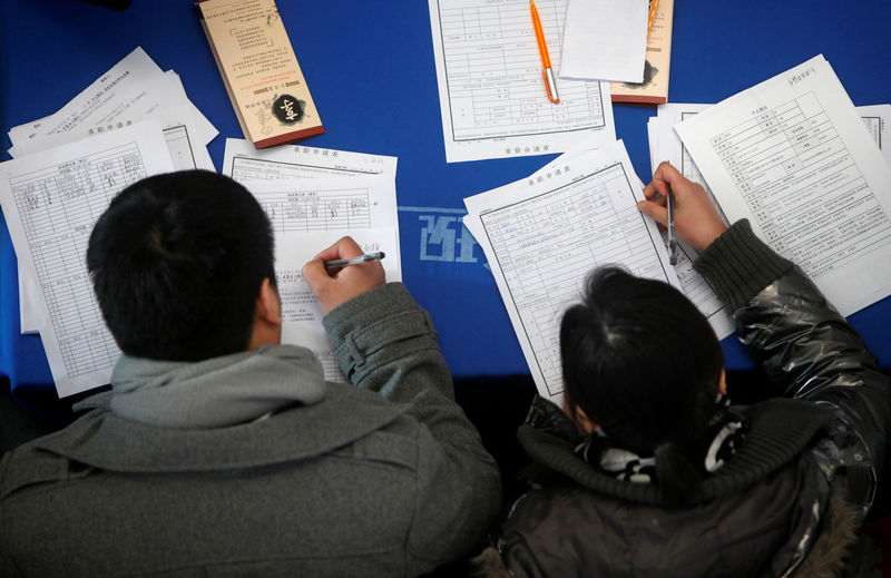 © Reuters. FILE PHOTO: Job seekers fill in application forms during a job fair at Shanghai Stadium