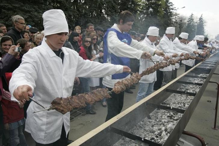 © Reuters. Повара демонстрируют шиш-кебаб длиной 120 метров в Черкесске