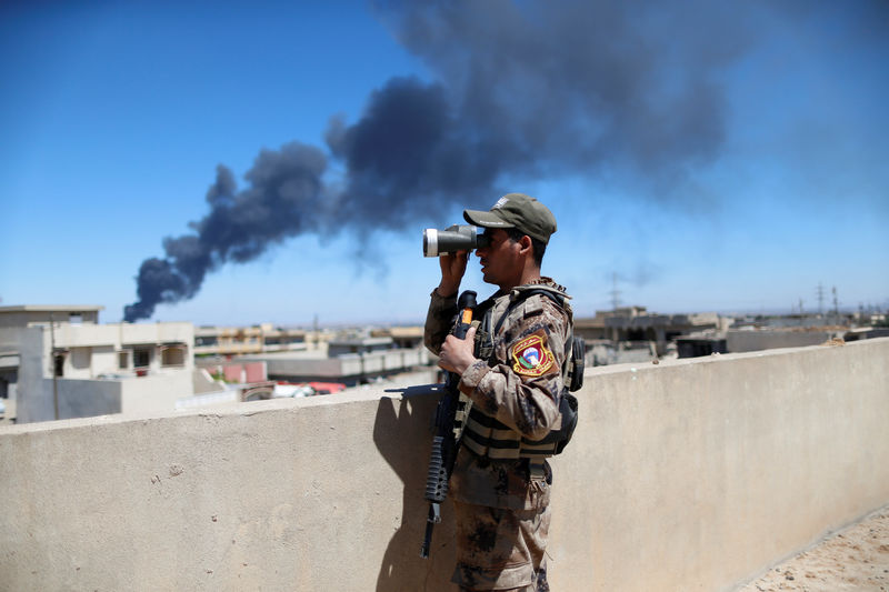 © Reuters. Um soldado das forças do Iraque utiliza binóculos durante uma batalha contra militantes do Estado Islâmico em Mosul
