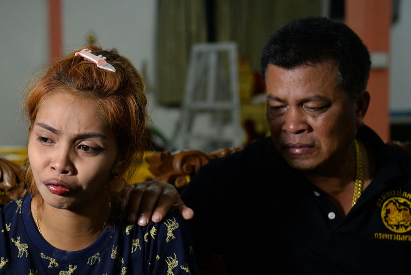 © Reuters. Jiranuch Trirat is comforted her by father at a temple in Phuket
