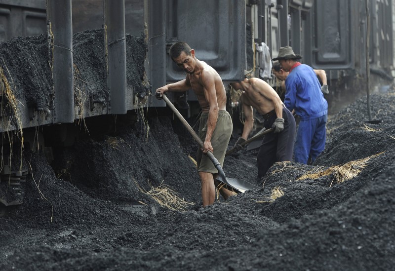 © Reuters. Labourers shovel coal at a coal storage site in Hefei