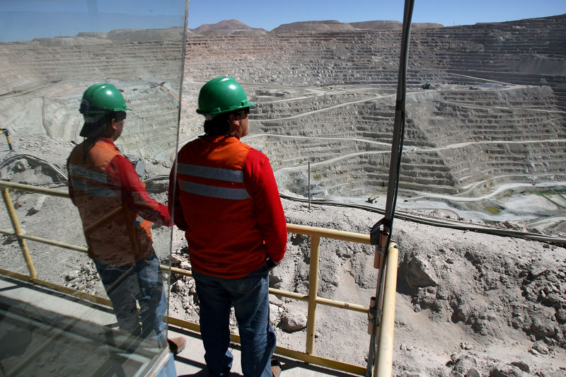 © Reuters. FILE PHOTO: Workers of BHP Billiton's Escondida, the world's biggest copper mine, are seen in front of the open pit, in Antofagasta,