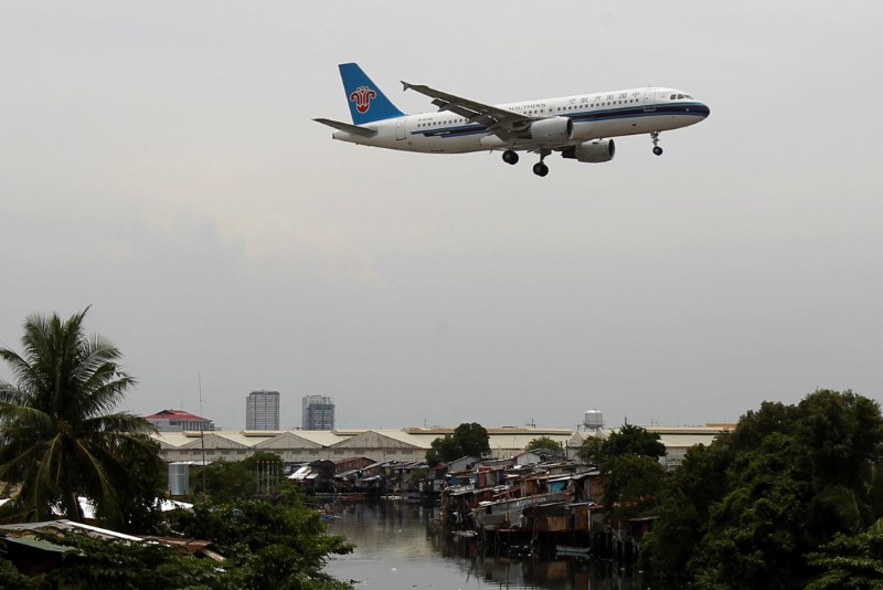 © Reuters. FILE PHOTO: A China Southern Airlines aircraft flies over a slum before landing at Manila's International airport