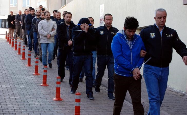 © Reuters. Suspeitos de apoiar o clérigo Fethullah Gulen são acompanhados por policiais, na Turquia