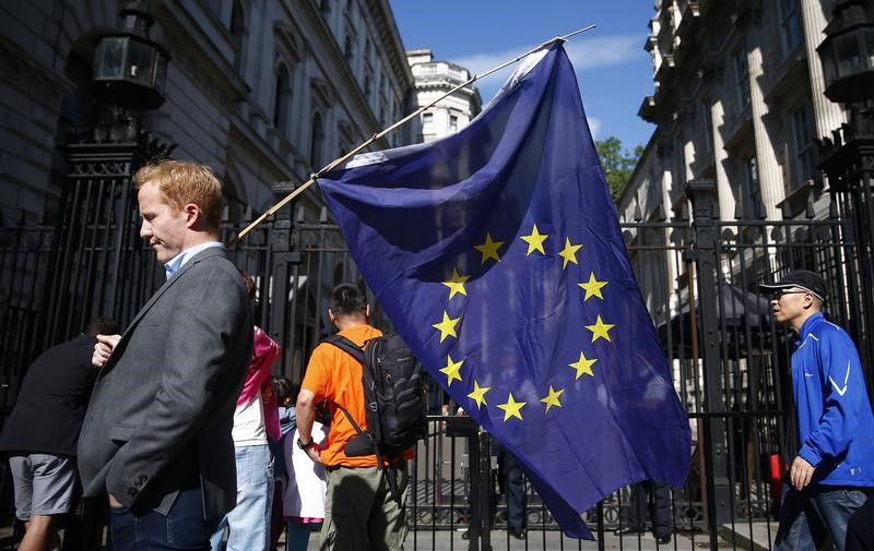 © Reuters. A man carries a EU flag, after Britain voted to leave the European Union, outside Downing Street in London