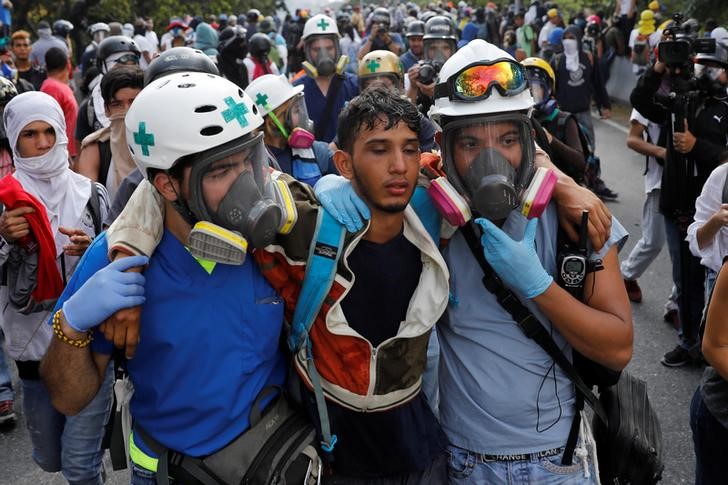 © Reuters. Voluntários ajudam manifestante ferido em Caracas