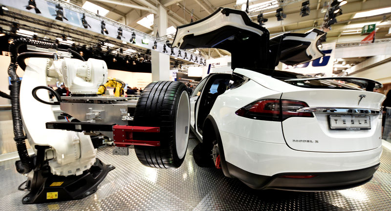 © Reuters. A robotic arm changes the tyre of a Tesla car at the world's biggest industrial fair, "Hannover Fair\\