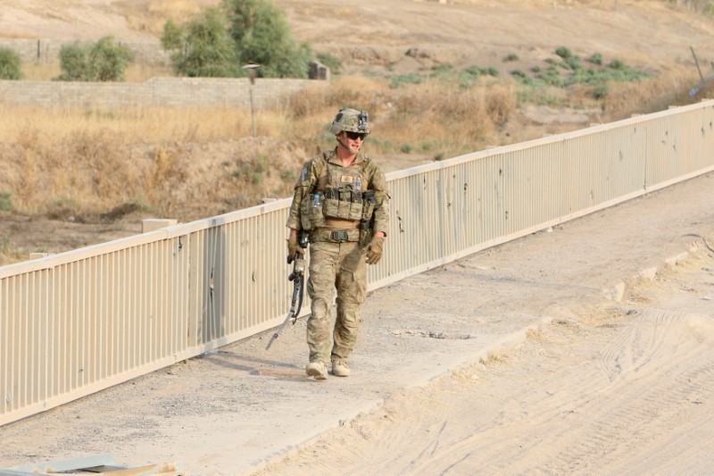 © Reuters. A U.S soldier walks on a bridge with his gun in the town of Gwer northern Iraq