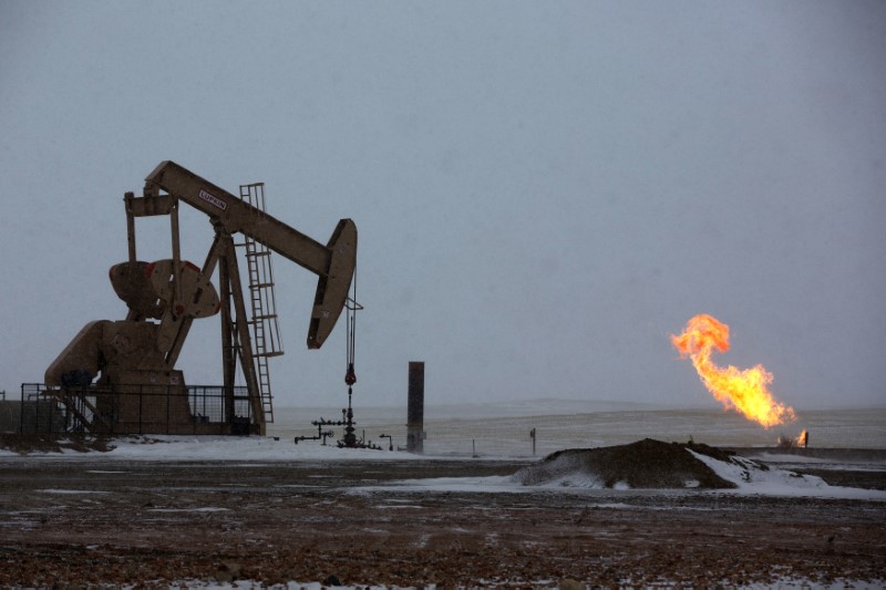 © Reuters. Natural gas flares are seen at an oil pump site outside of Williston