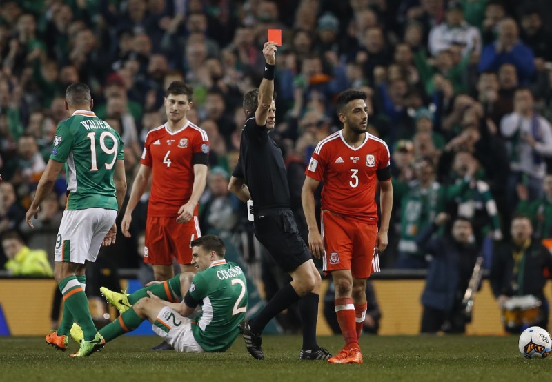 © Reuters. Wales' Neil Taylor is sent off by referee Nicola Rizzoli as Republic of Ireland's Seamus Coleman lies injured