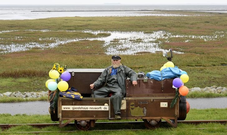 © Reuters. Nissen poses on his trolley on the track to the tiny islands of Oland and Langeness in the North Sea during his last working-day