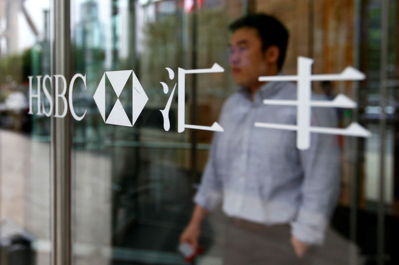 © Reuters. FILE PHOTO: A man walks past the HSBC logo at the bank's new China headquarters in Shanghai