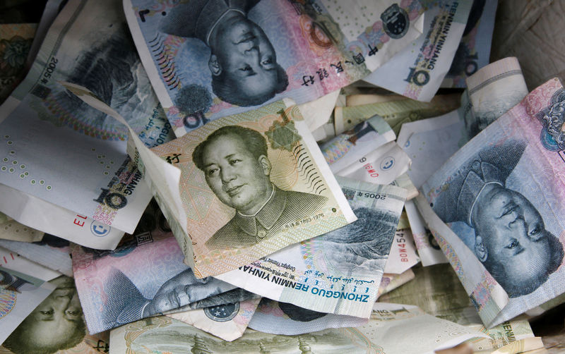 © Reuters. FILE PHOTO: Chinese Yuan bank notes are seen at a vendor's cashbox at a market in Beijing