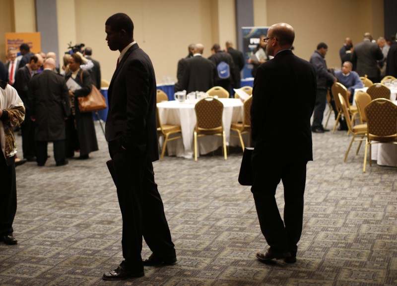 © Reuters. Job seekers stand in a room of prospective employers at a career fair in New York City