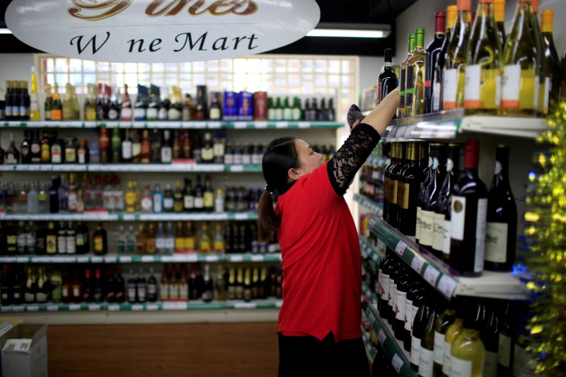 © Reuters. A staff member checks bottles of wine at a mart in Shanghai