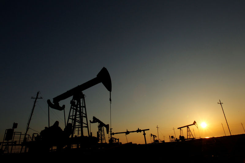 © Reuters. FILE PHOTO: Pump jacks are silhouetted against the rising sun at an oilfield in Baku