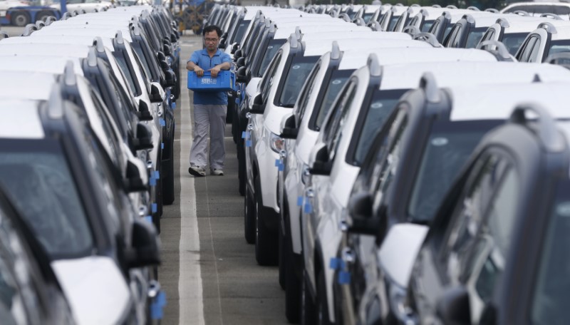© Reuters. A worker checks cars made by South Korea's automakers Hyundai Motor and affiliate Kia Motors at their shipping yard at a port in Pyeongtaek