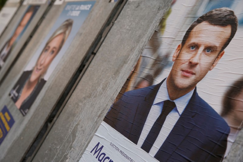 © Reuters. Campaign posters of Marine Le Pen and Emmanuel Macron, two of the eleven candidates who run in the 2017 French presidential election, are seen in Paris