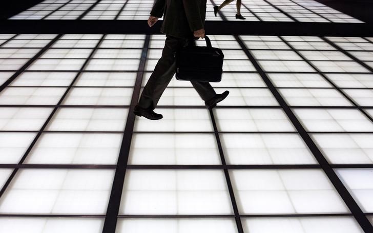 © Reuters. People cross an illuminated floor at a banking district in central Tokyo