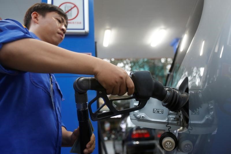 © Reuters. An employee pumps petrol into a car at a petrol station in Hanoi