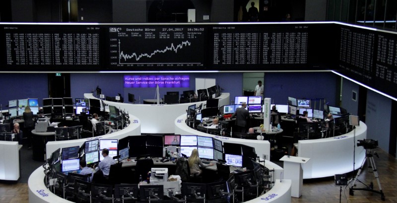 © Reuters. Traders work at their desks in front of the German share price index DAX board in Frankfurt