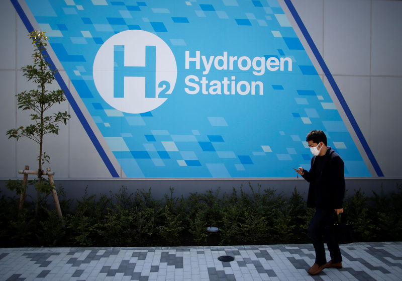 © Reuters. A passerby walks past in front of a hydrogen station in Tokyo
