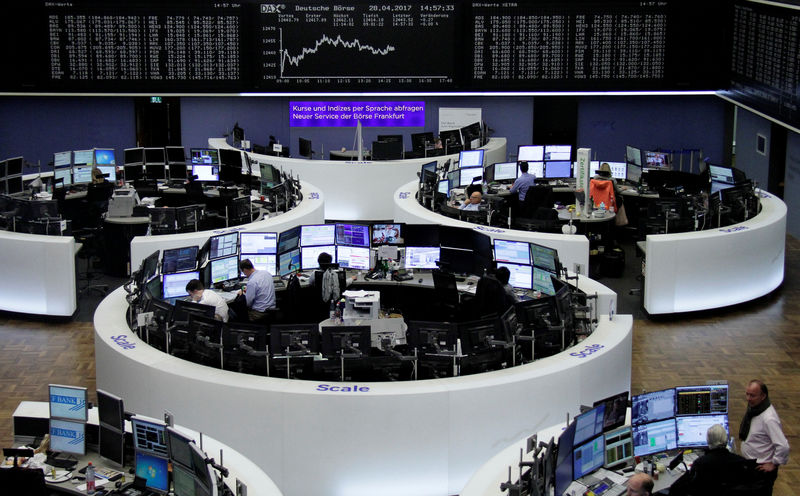 © Reuters. Traders work at their desks in front of the German share price index DAX board in Frankfurt