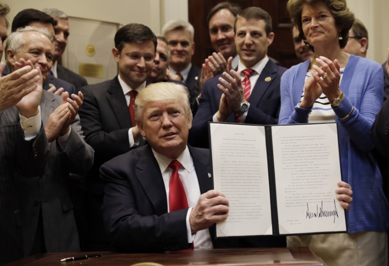 © Reuters. U.S. President Trump displays an Executive Order on the administration's energy strategy at the White House in Washington