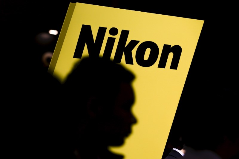© Reuters. People are silhouetted against a display of the Nikon brand logo at the CP+ camera and photo trade fair in Yokohama