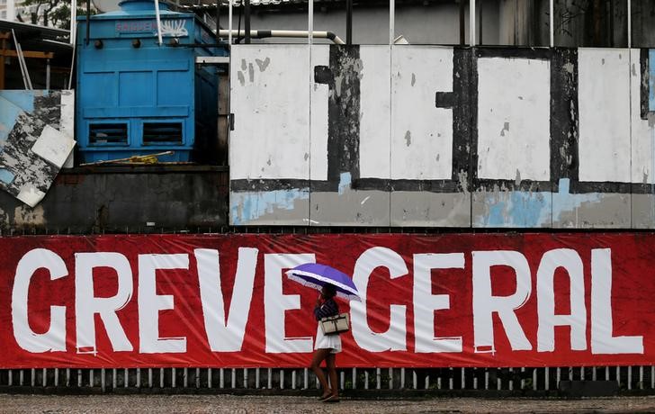 © Reuters. Mulher passa por faixa sobre greve geral no Rio de Janeiro
