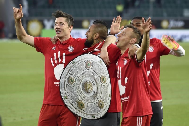 © Reuters. Arturo Vidal, Robert Lewandowski y Rafinha del Bayern Munich celebran tras ganar la Bundesliga