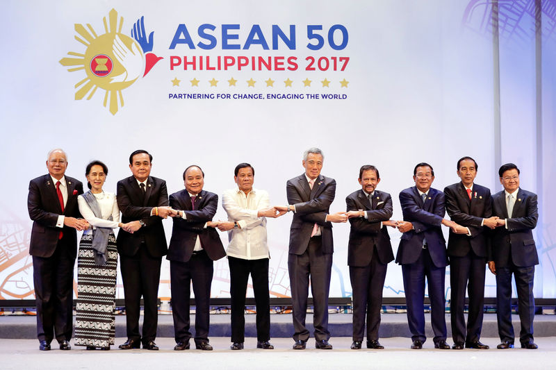 © Reuters. ASEAN leaders link arms during the opening ceremony of the 30th ASEAN Summit in Manila