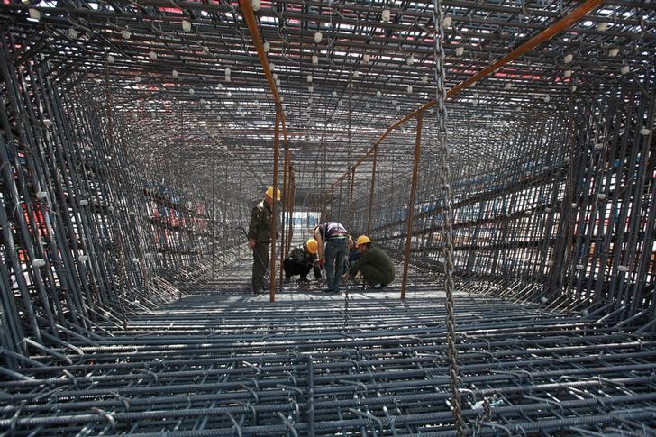 © Reuters. Labourers work on construction site of high-speed railway in Linyi
